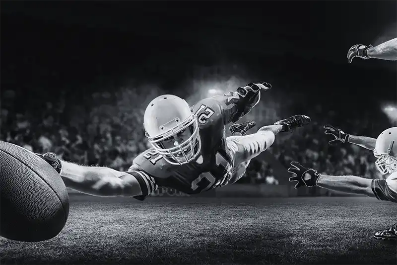 football player stretching football across goal line with great sports performance